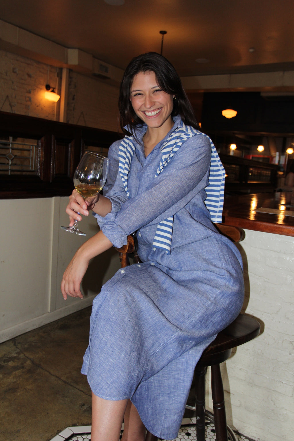 Model wearing Frank & Eileen Rory blue linen shirt dress styled as a coastal luxury vacation outfit